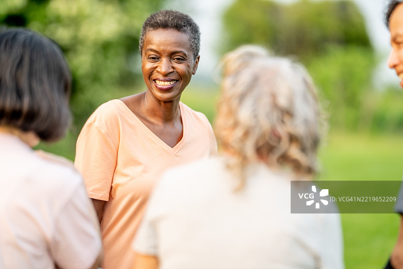 快乐的老年女性与朋友们在户外社交享受时光图片素材