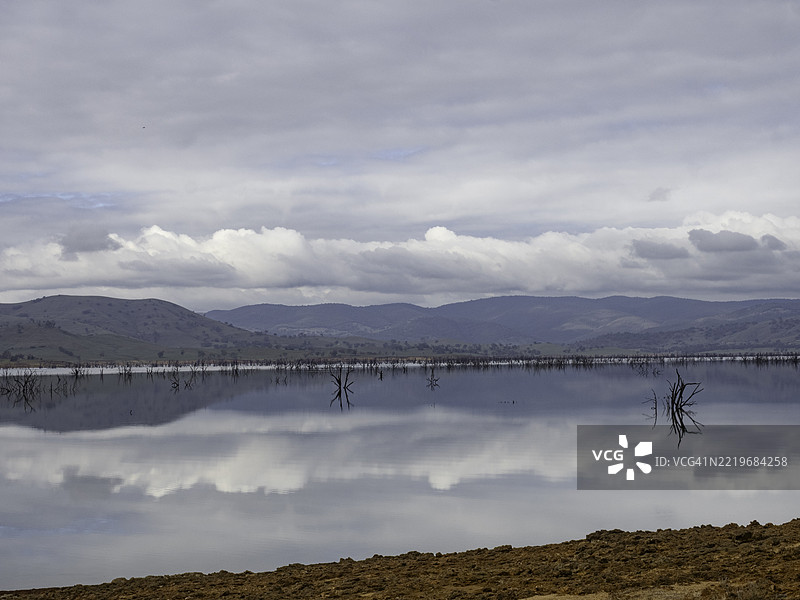 湖面上云朵和树木的阴郁倒影图片素材