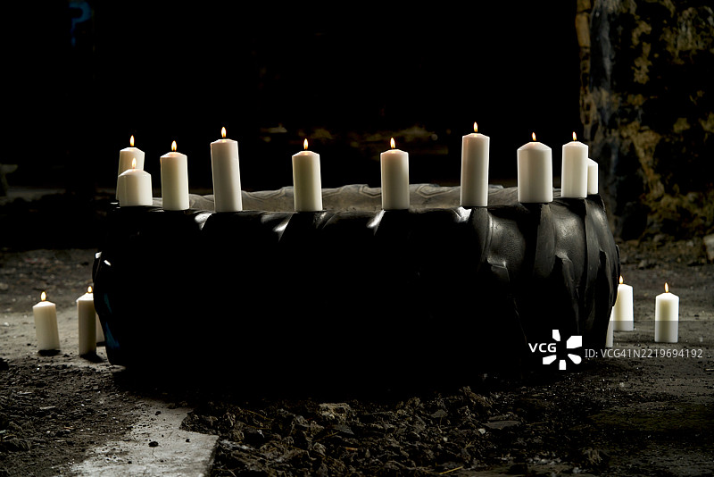在黑暗的废弃地方，轮胎上燃烧着蜡烛图片素材