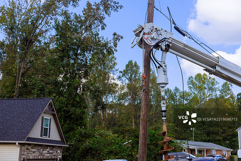 电力维修队在阳光明媚的日子里用钻孔机修理电力线路图片素材