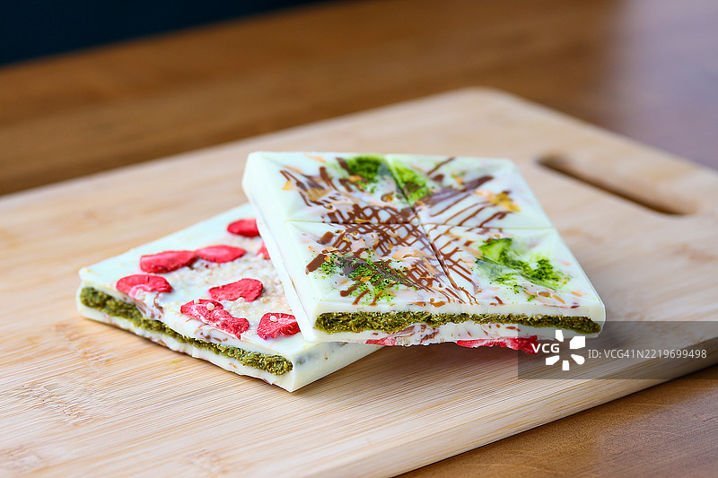 白巧克力棒配抹茶草莓和坚果，放在木板上图片素材