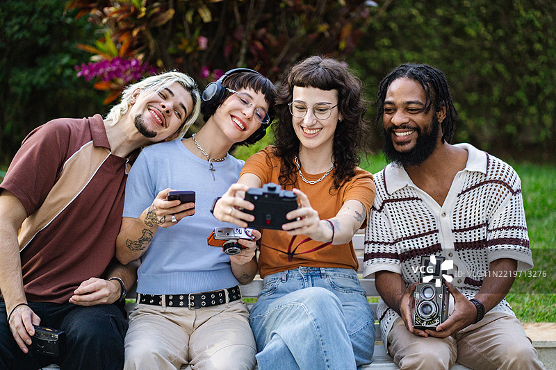 一群年轻朋友在使用老式胶卷相机互动图片素材