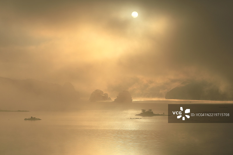 在秋本湖浓雾中，景色终于显现出来。图片素材