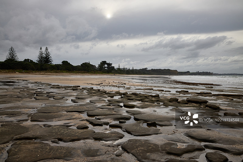 长湾的低潮与岩石形成图片素材