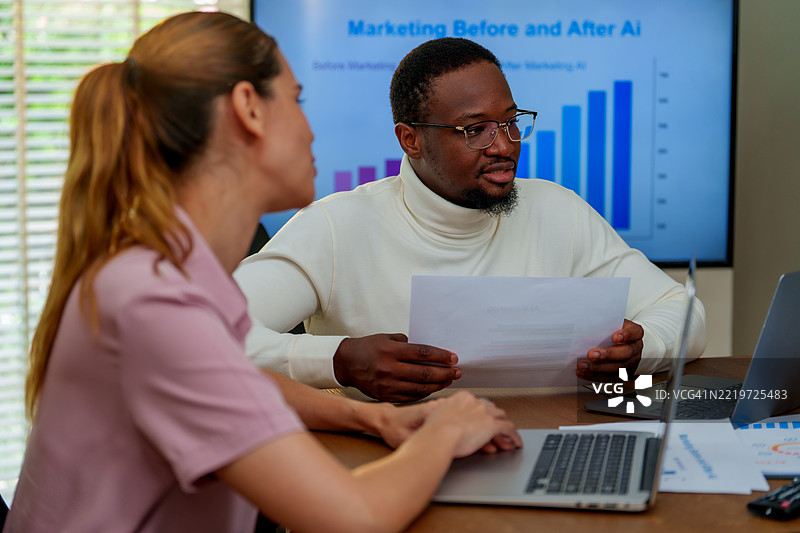 在现代商业环境中，两位专业人士就技术和营销策略进行讨论，分析与人工智能对营销影响相关的数据。他们的合作突显了重要性。图片素材