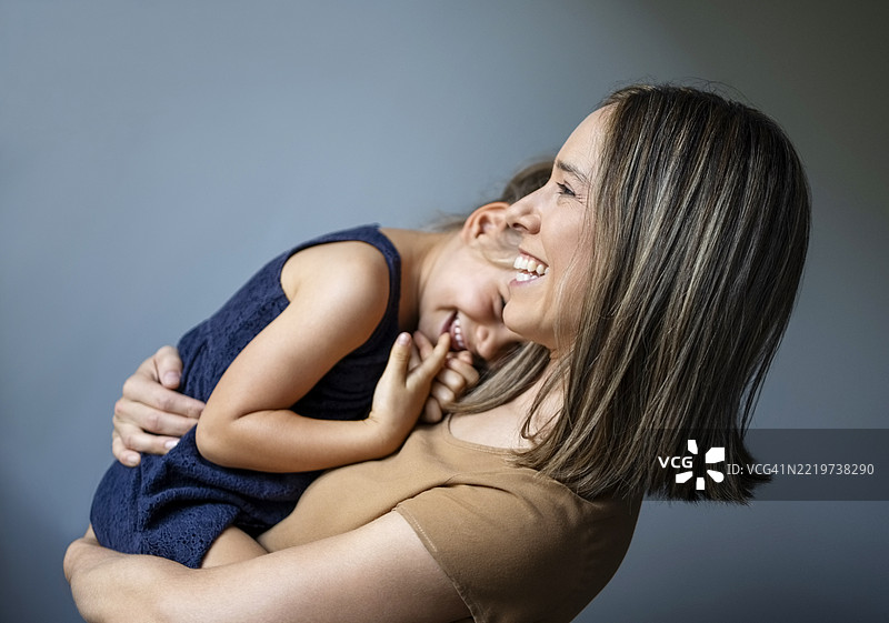 母亲抱着害羞的女儿图片素材