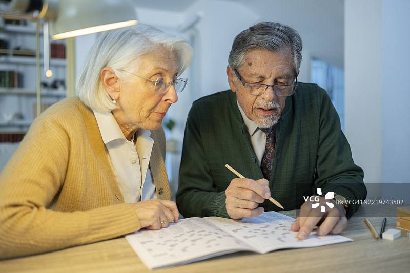 老年夫妇在家一起解填字游戏图片素材