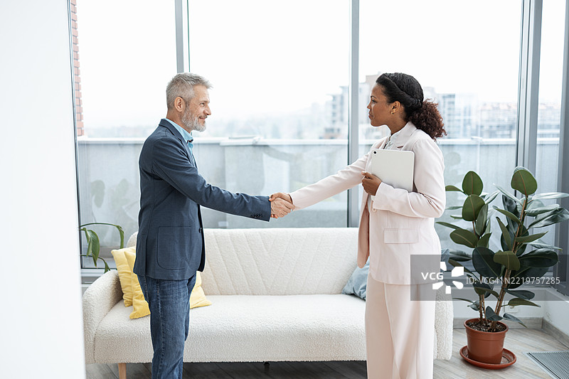 在专业办公室环境中展示团队合作的商务握手图片素材