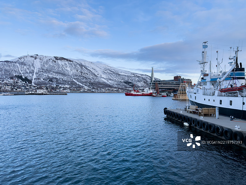 黎明时分的雪山港口与停靠的船只图片素材