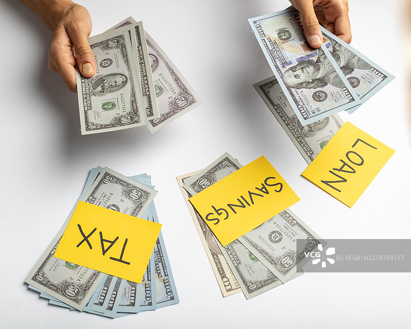 手在分发税收、储蓄和贷款概念的钱。图片素材