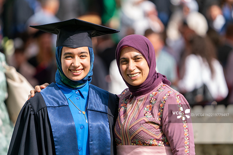 年轻的戴头巾女性与母亲庆祝毕业，母爱的温暖图片素材