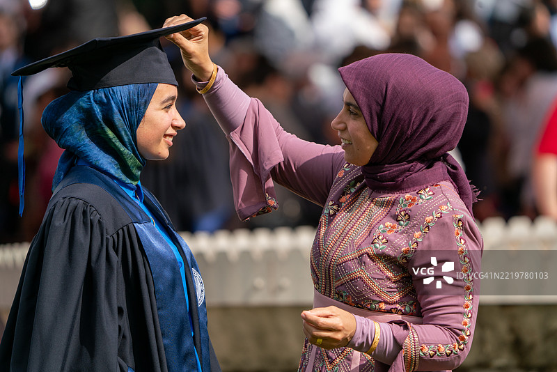 年轻的戴头巾女性与母亲庆祝毕业，母爱的体现图片素材