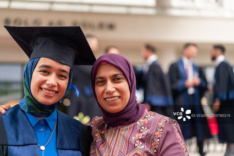年轻的戴头巾女性与母亲庆祝毕业，母爱的温暖图片素材