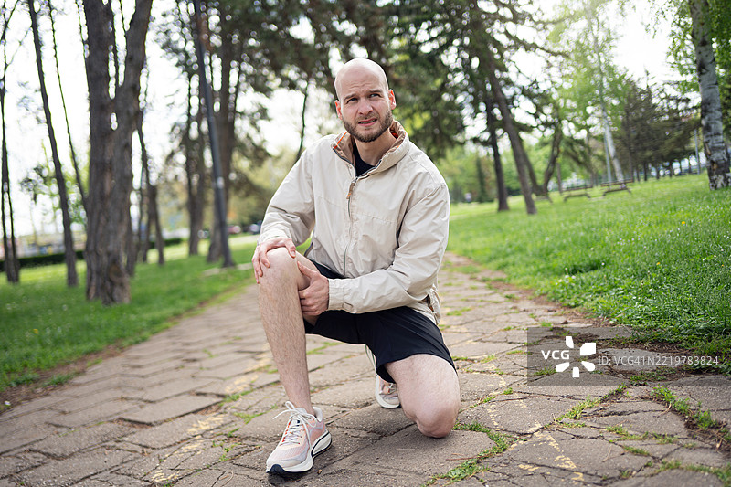 年轻男子在公园户外进行锻炼时跪下图片素材