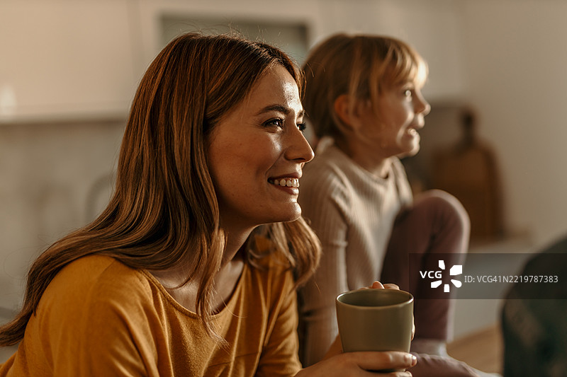 母女俩在家一起看电视，享受轻松的夜晚时光图片素材