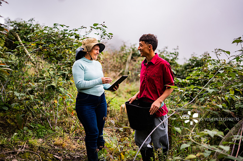 农民在农场上交谈并使用数字平板电脑图片素材
