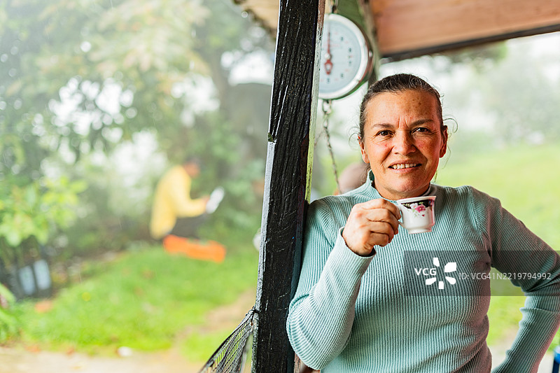 一位女性农民在农场喝咖啡的肖像图片素材
