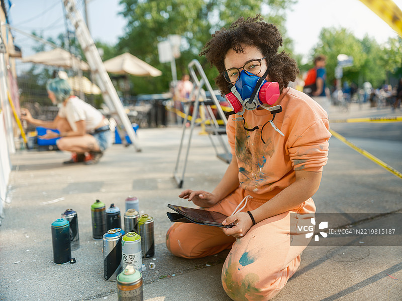年轻的墨西哥女性在城市建筑的外立面上创作壁画图片素材