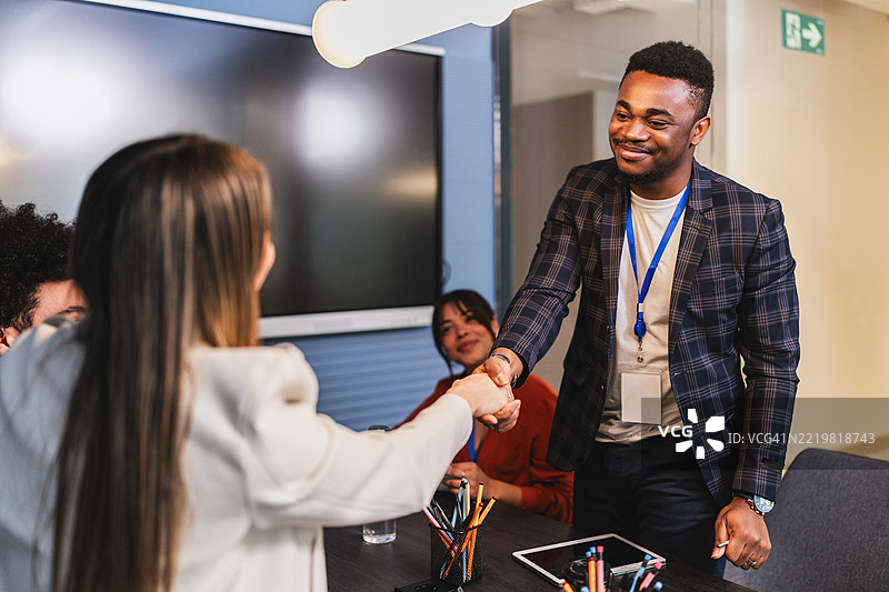 商务人士在现代办公室会议中握手图片素材