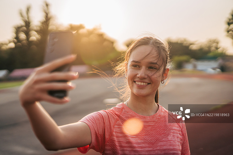年轻的运动女性在户外训练后自拍图片素材
