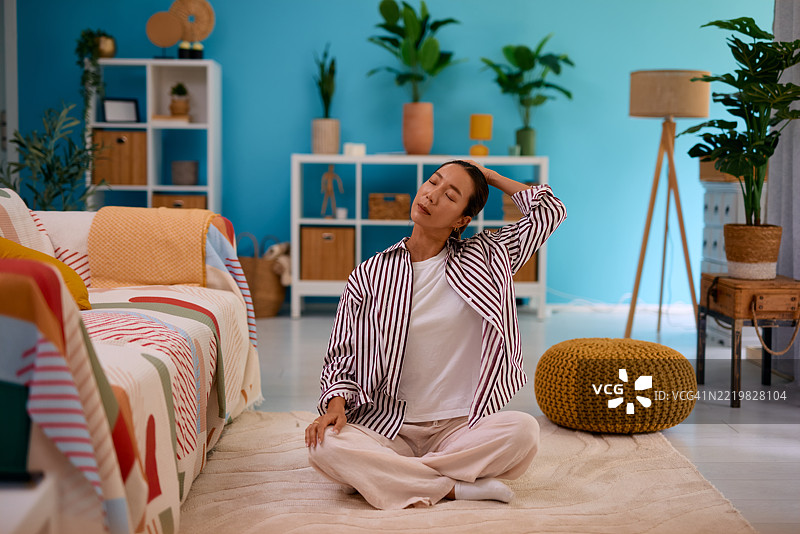 年轻女性在舒适的客厅里伸展脖子图片素材