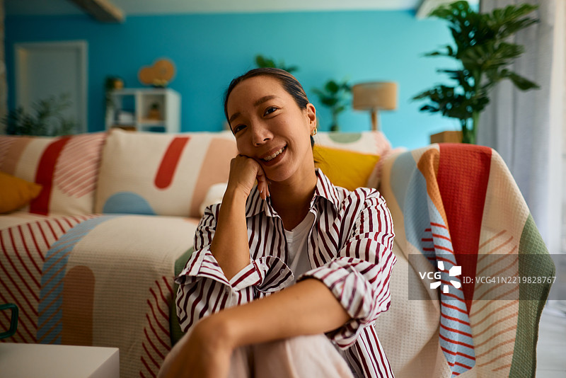 年轻女性在客厅的地板上放松。图片素材