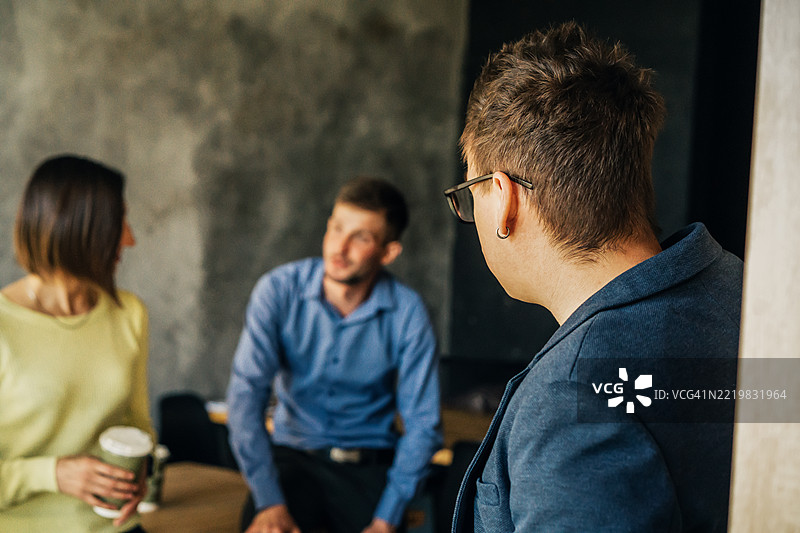 同事们在现代办公室环境中讨论图片素材