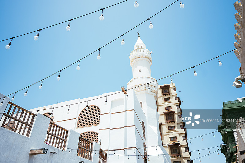 在吉达的历史区阿尔巴拉德，清澈的蓝天下，沙特阿拉伯的清真寺和传统建筑的街景图片素材