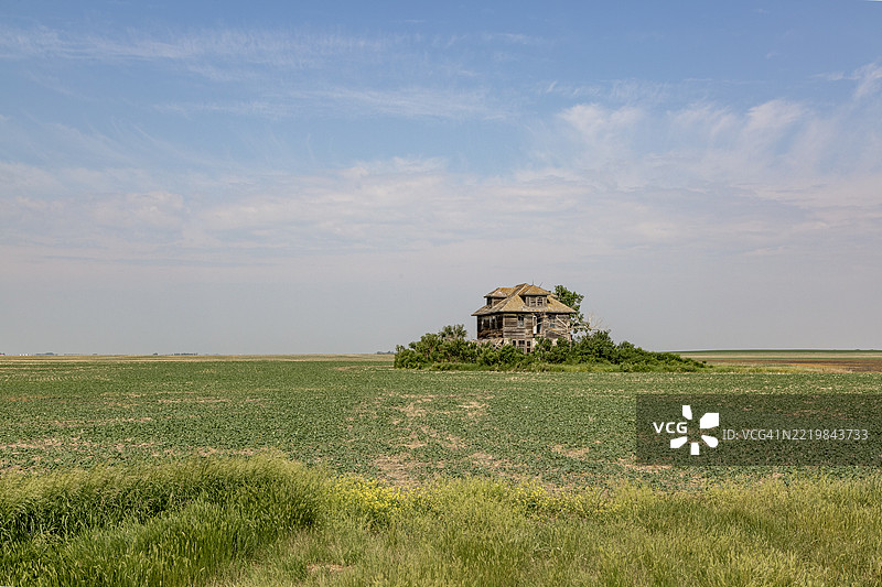 一座位于广阔草原上的大型废弃农舍图片素材