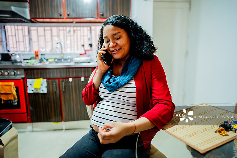 年轻孕妇在家中打手机电话图片素材