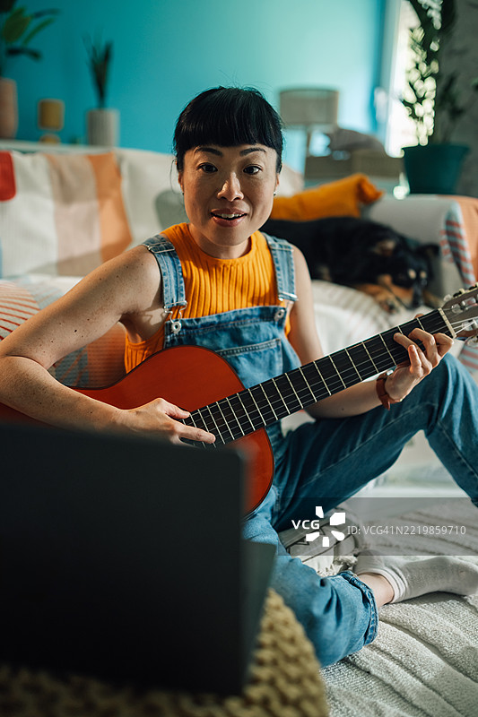 在家通过在线课程学习弹吉他的女性图片素材