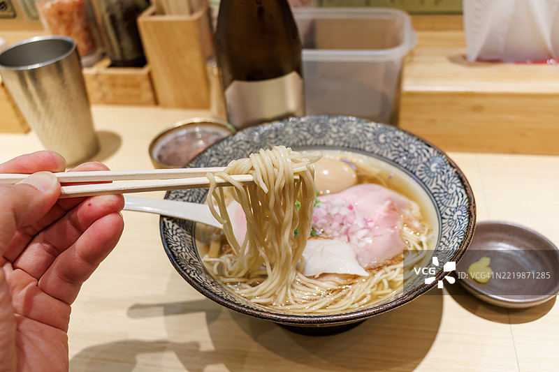 清淡口味的鲷鱼拉面（用鲷鱼高汤制作的日本拉面），上面还放有一个半熟蛋和生啤酒。图片素材