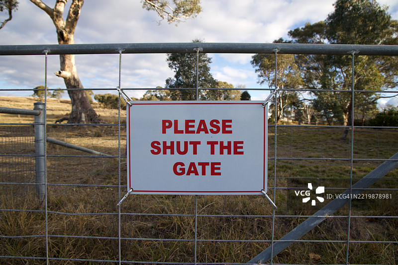 标志上写着“请关上大门”，位于乡村房产的出入口处图片素材