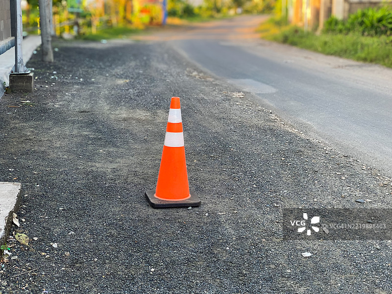 受损道路旁的三角形交通锥图片素材