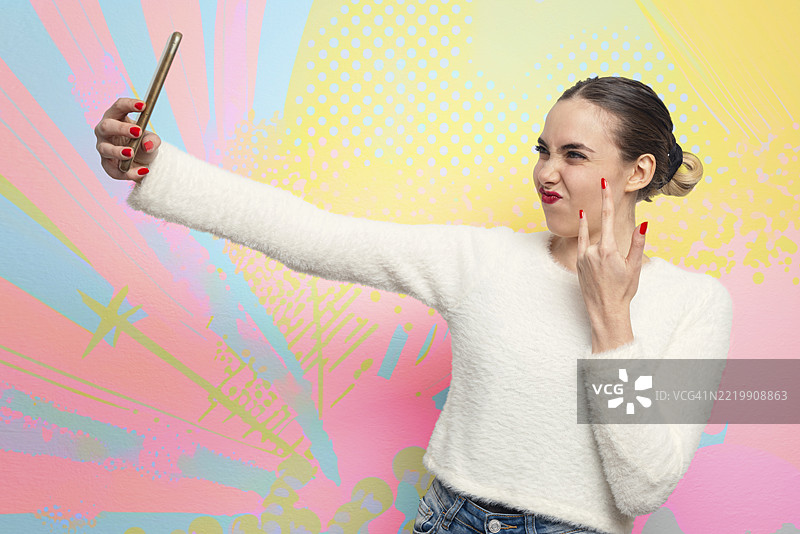 女人自拍并做出摇滚手势图片素材