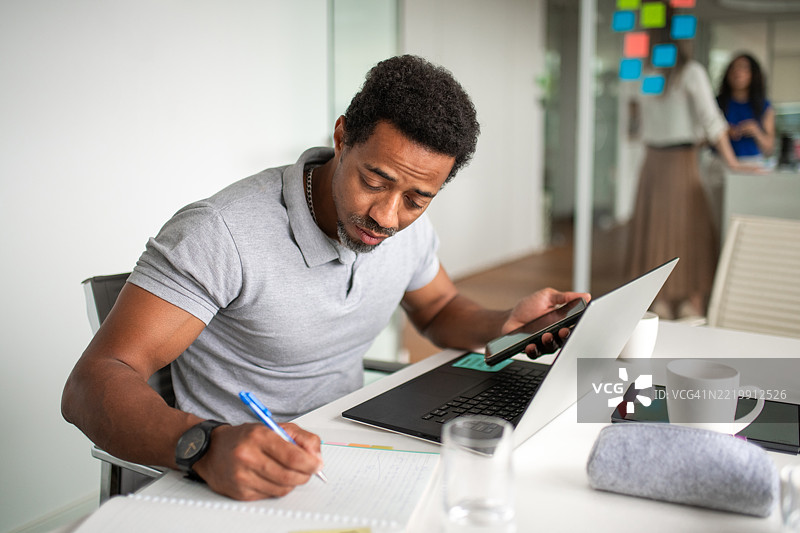 专注的中年黑人商务专业人士在现代会议室工作图片素材