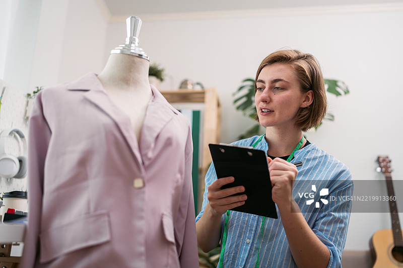 女性企业家在她的创意家居工作室设计服装图片素材