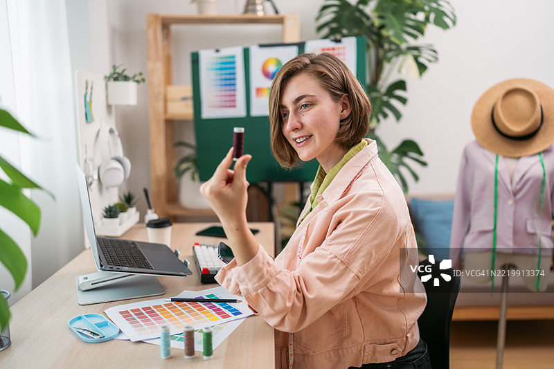 女性设计师为新系列选择颜色。创意经济，独立创业，设计思维，决策，可持续时尚，居家创业，个性化。图片素材