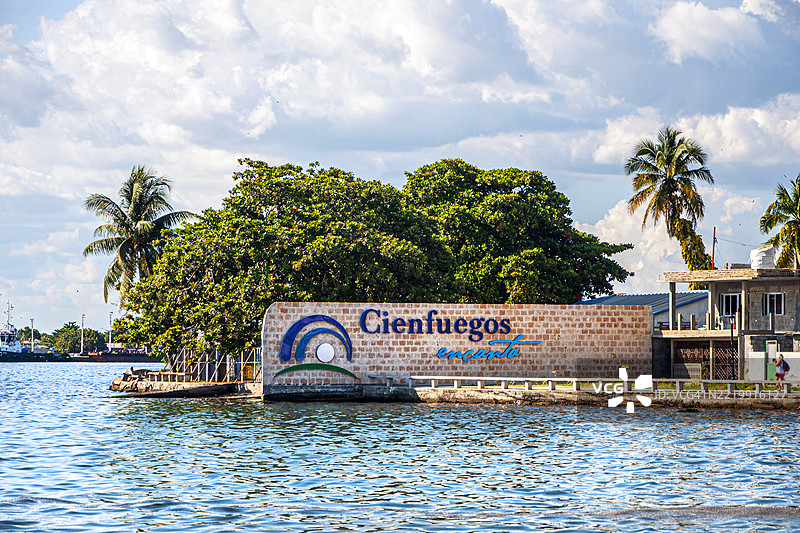 锡恩富戈斯海滨。锡恩富戈斯马雷孔。城市名称的标志。阳光明媚的日子里，棕榈树和海洋。锡恩富戈斯，古巴。图片素材