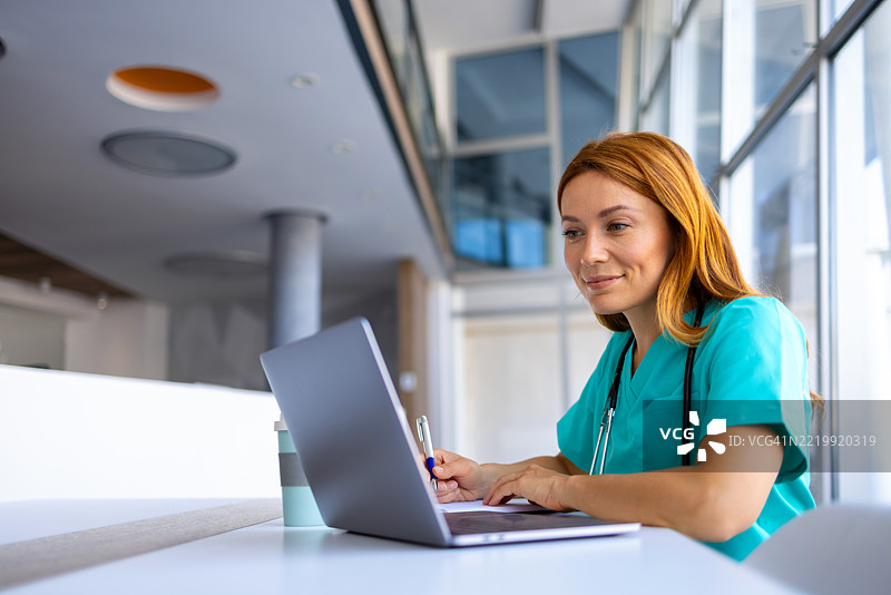 女性医生在现代医院使用笔记本电脑工作图片素材