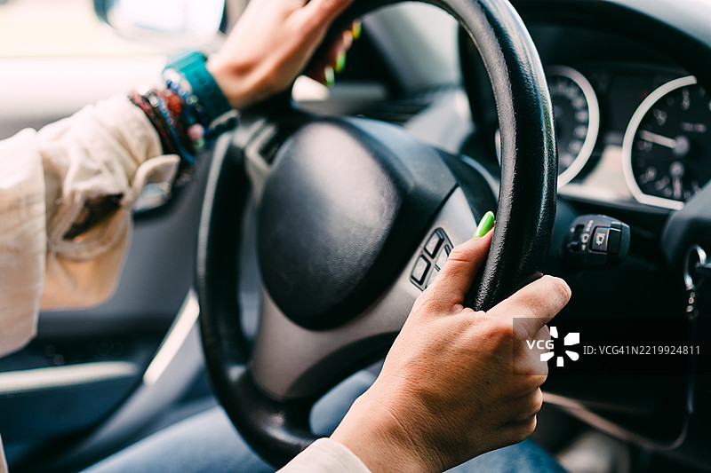 特写镜头：一位女性的手握住汽车方向盘图片素材