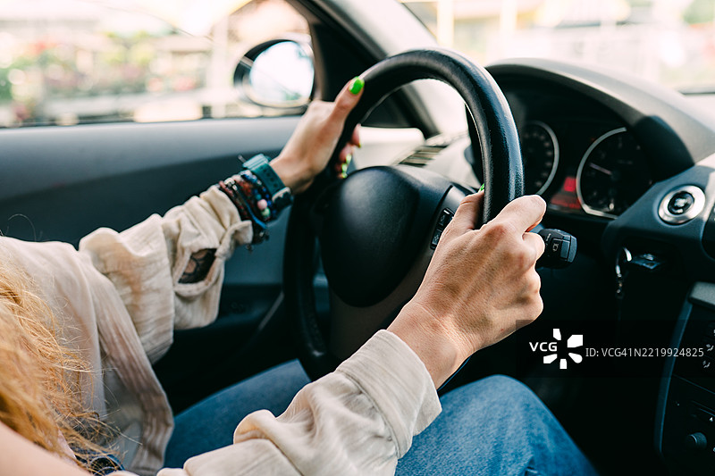 特写镜头：一位女性的手握住汽车方向盘图片素材