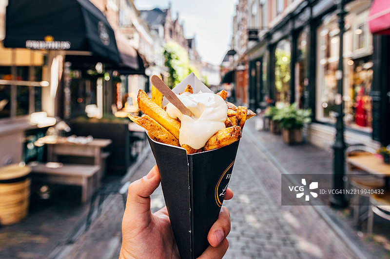 在荷兰阿姆斯特丹以个人视角享用比利时薯条（Pommes Frites）配蛋黄酱图片素材