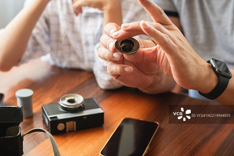 父亲向儿子展示一台老式复古相机图片素材