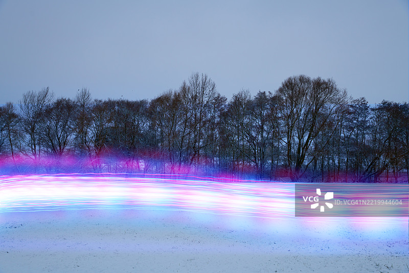 雪覆盖的田野中发光的光轨图片素材
