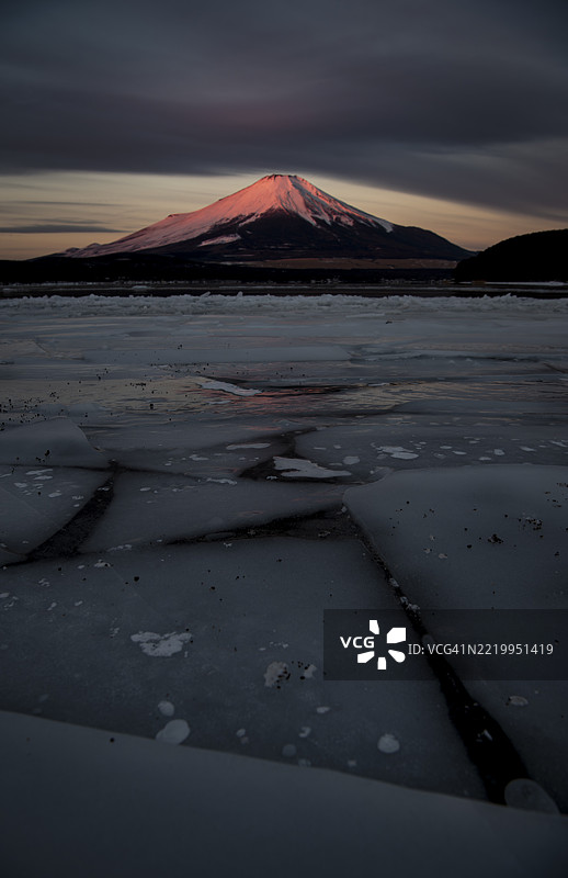 清晨冰冻湖面上泛着粉色的富士山图片素材