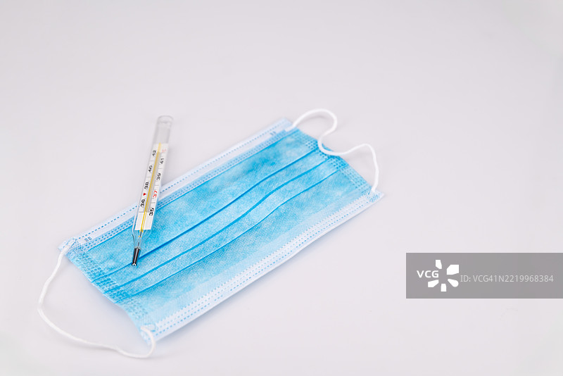 白色背景上的药丸、温度计和口罩。图片素材