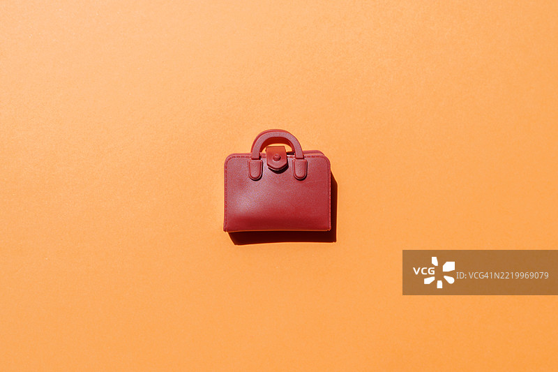 红色皮革公文包放在橙色背景上图片素材