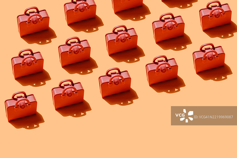 橙色背景上红色行李箱的图案投射出阴影图片素材