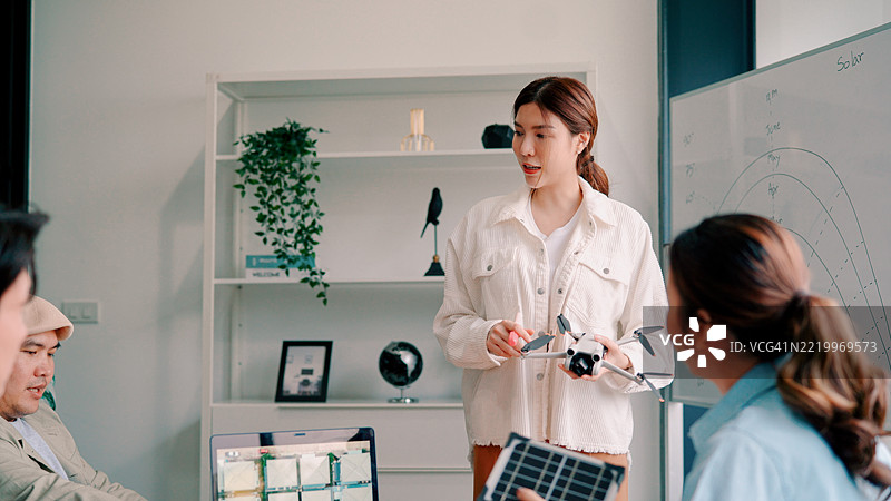 年轻的亚洲男女在会议室开会讨论下个季度的策略。图片素材